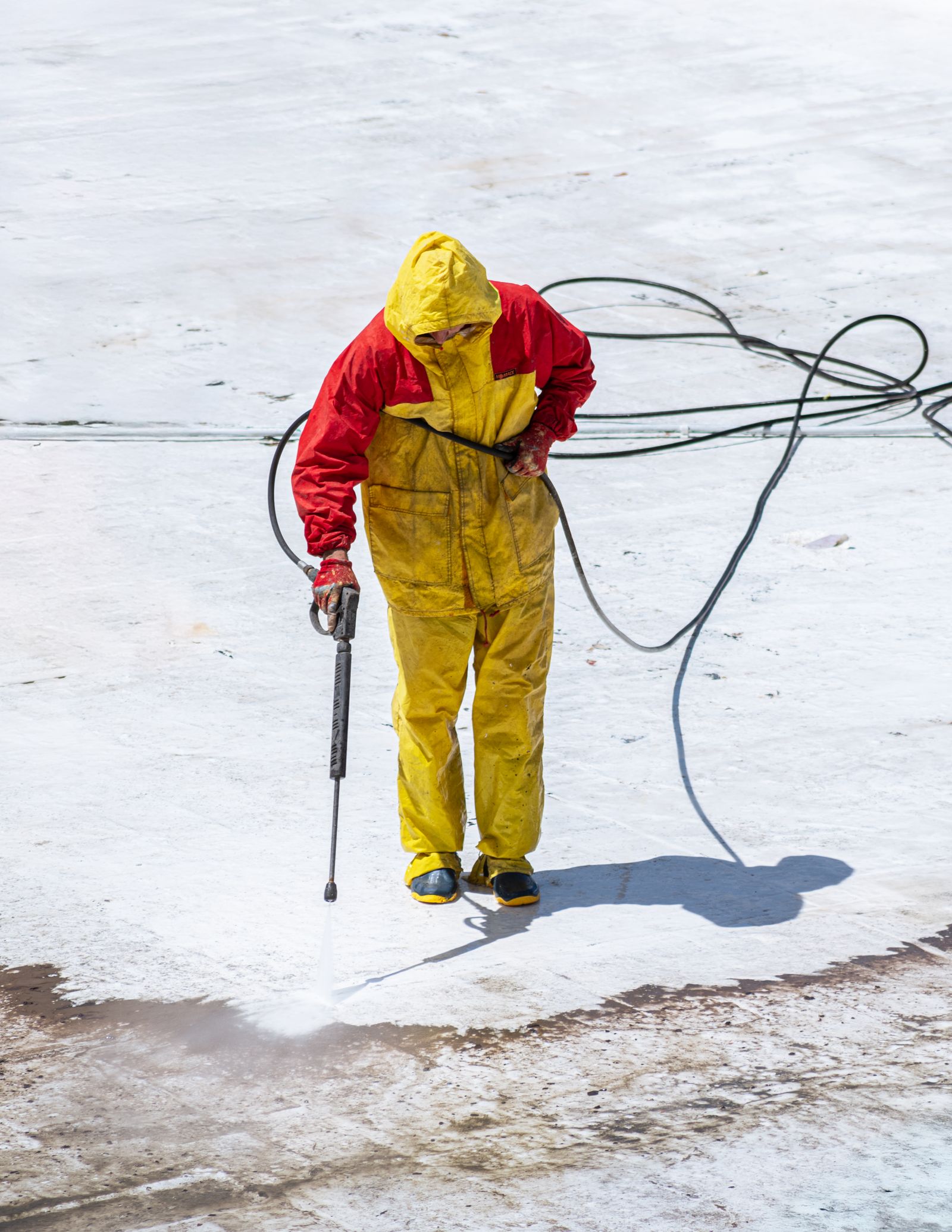 Pressure washing a concrete patio, half clean and half dirty